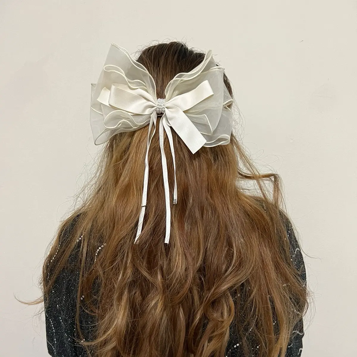 Beige bow with 3.5 inch Barrette hair clip attachment in the back. This clip is great for all ages and all hair type. This clip has some rhinestone in the middle of the bow. This bow is a combination of two types of clothing material with 4 dangling strip