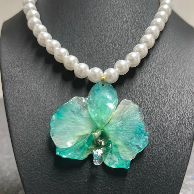 Collar con orquídeas naturales bañadas en resina.