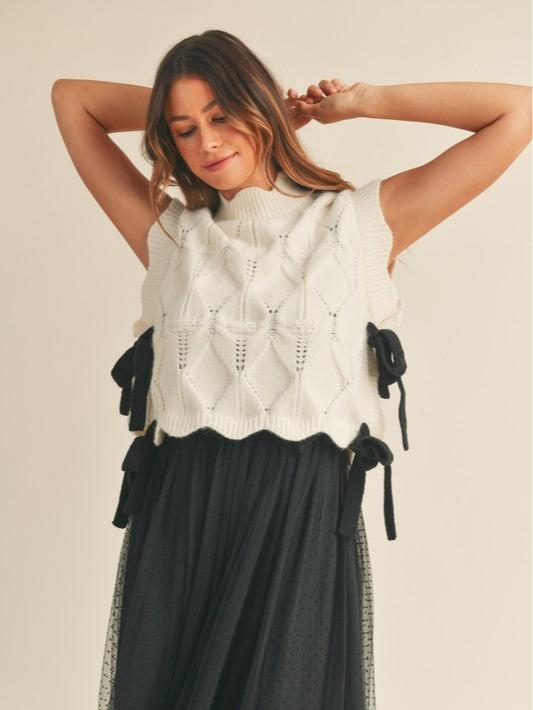 Wishlist Vest - White comfy cable knit sweater vest with scallop details, black side bows, and a turtleneck, offering a slightly oversized fit