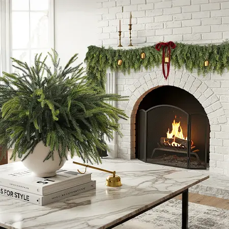 Artificial Norfolk pine arrangement beside Christmas fireplace decor