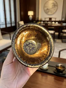 Handcrafted tea cup made by renowned artisan Huang Meijin from Jianzhan porcelain, featuring a golden oil drip design.