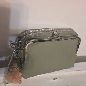 Name Sleek Sage Green Crossbody Bag with Detachable Strap and Tassel Charm for Everyday Use