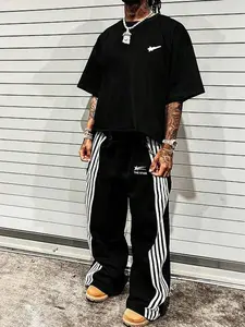 This men's two-piece set, Striped Lounge Set, includes a star-patterned T-shirt and trousers featuring lettering and a star design. Made from a knit fabric, it's suitable for everyday wear and can be worn year-round.