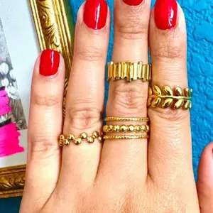 (D) Set de 4 anillos ajustables en tono dorado, Acero inoxidable.