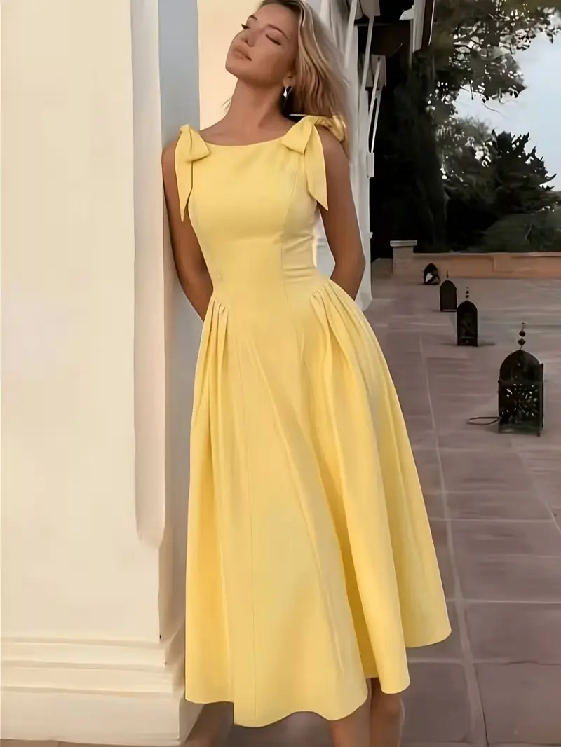 A vintage-style bow-tie dress for women, featuring a fitted waist and a voluminous, apron-style skirt. Adorned with bows on the shoulder straps, it exudes a gentle elegance—perfect for dates, outings, and various other occasions.