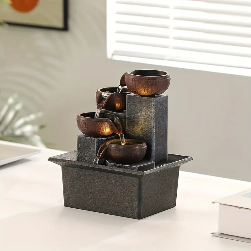 A Single Indoor Fountain Featuring a Four-Tier Waterfall Design, Equipped with Warm LED Lighting And a Water Pump That Can Be Adjusted to Three Different Levels, Ideal for Enhancing The Decor of Small Desks in Both Homes And Offices