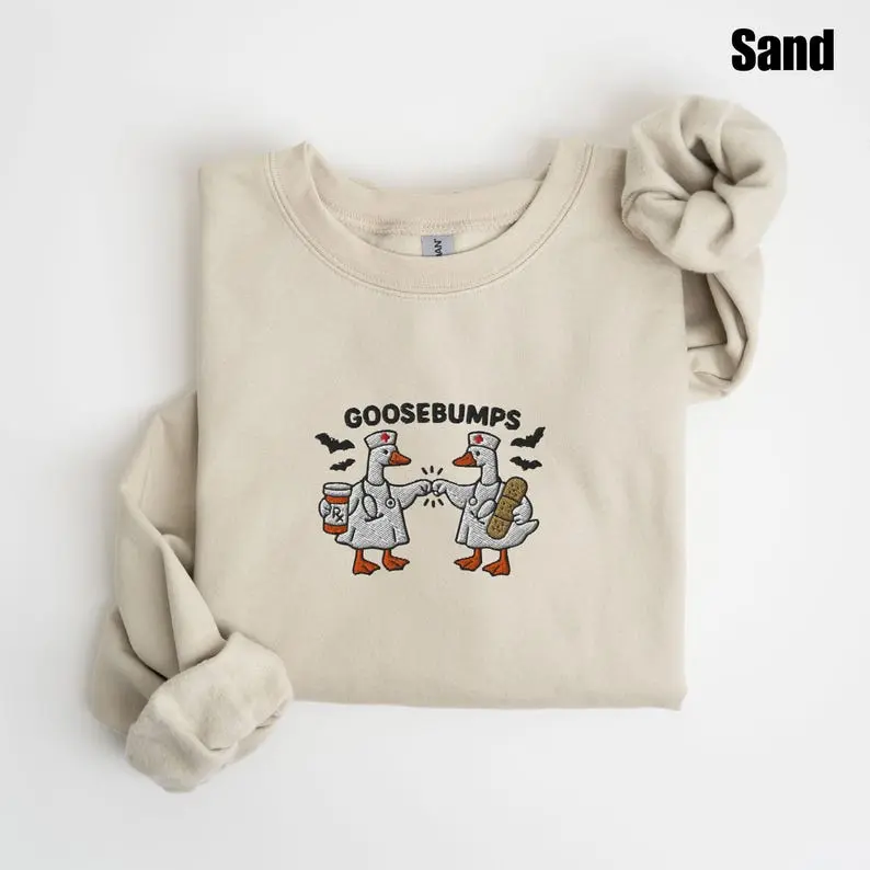 Embroidered Goosebump Nurse Duck Sweatshirt, T-shirt, And Hoodie, Cotton Apparel With Cute Geese Wearing Medical Scrubs And Stethoscopes Fist Bumping Graphic, Healthcare Worker Clothing