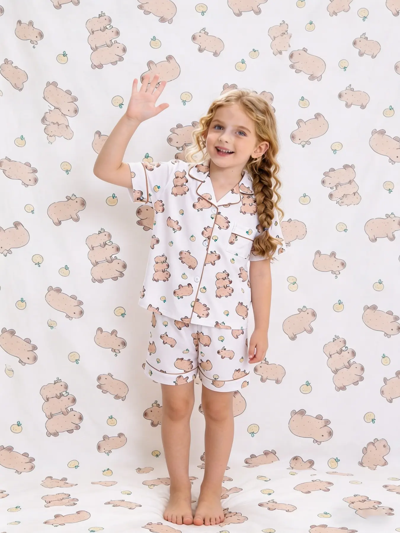 2-piece set of children's clothing for boys and girls, white background, full body, stacked Kapibala orange pattern print, short sleeved shorts, soft and comfortable lapel design, small pocket top, elastic waistband, home children's clothing, pajamas set