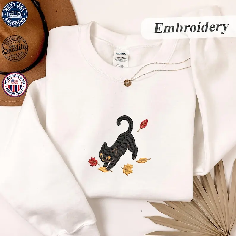 Embroidered Black Cat Fall Leaves Sweatshirt, T-shirt, And Hoodie, Cotton Apparel With Cute Kitty And Autumn Foliage Graphic, Comfortable Casual Clothing For Cat Lovers And Halloween