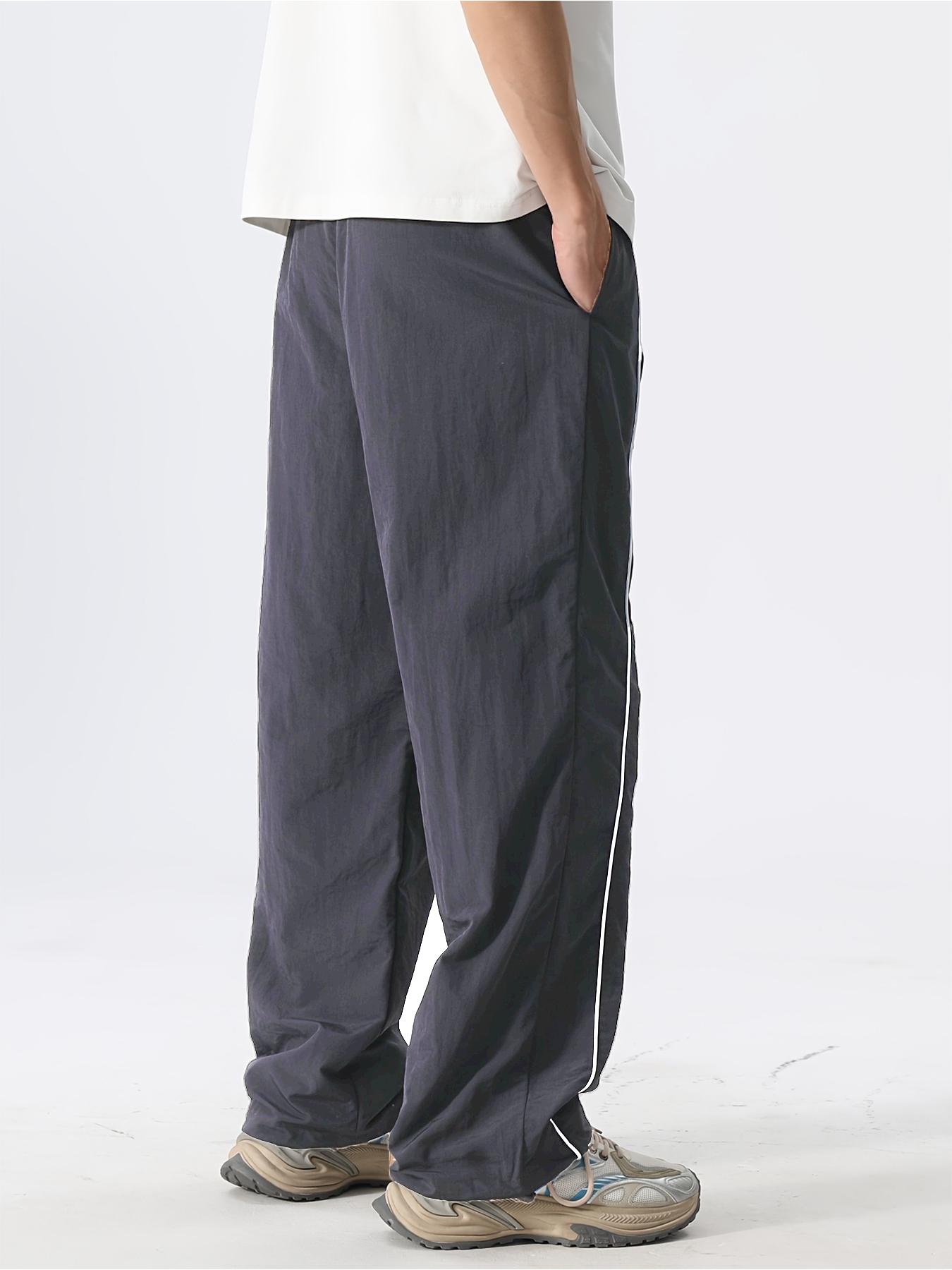 Men’s fashion loose fit long pants with side stripe paneling, drawstring waist, and elastic cuffs—perfect for everyday casual wear.
