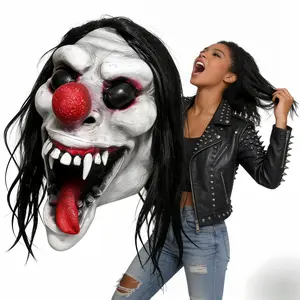 A bizarre and contrasting full-head latex mask featuring a clown, red nose, black eyes, a bright red tongue, sharp fangs, pale wrinkled skin, and long black hair. Suitable for Halloween horror costumes, ghost/clown cosplay, haunted house escape rooms, car