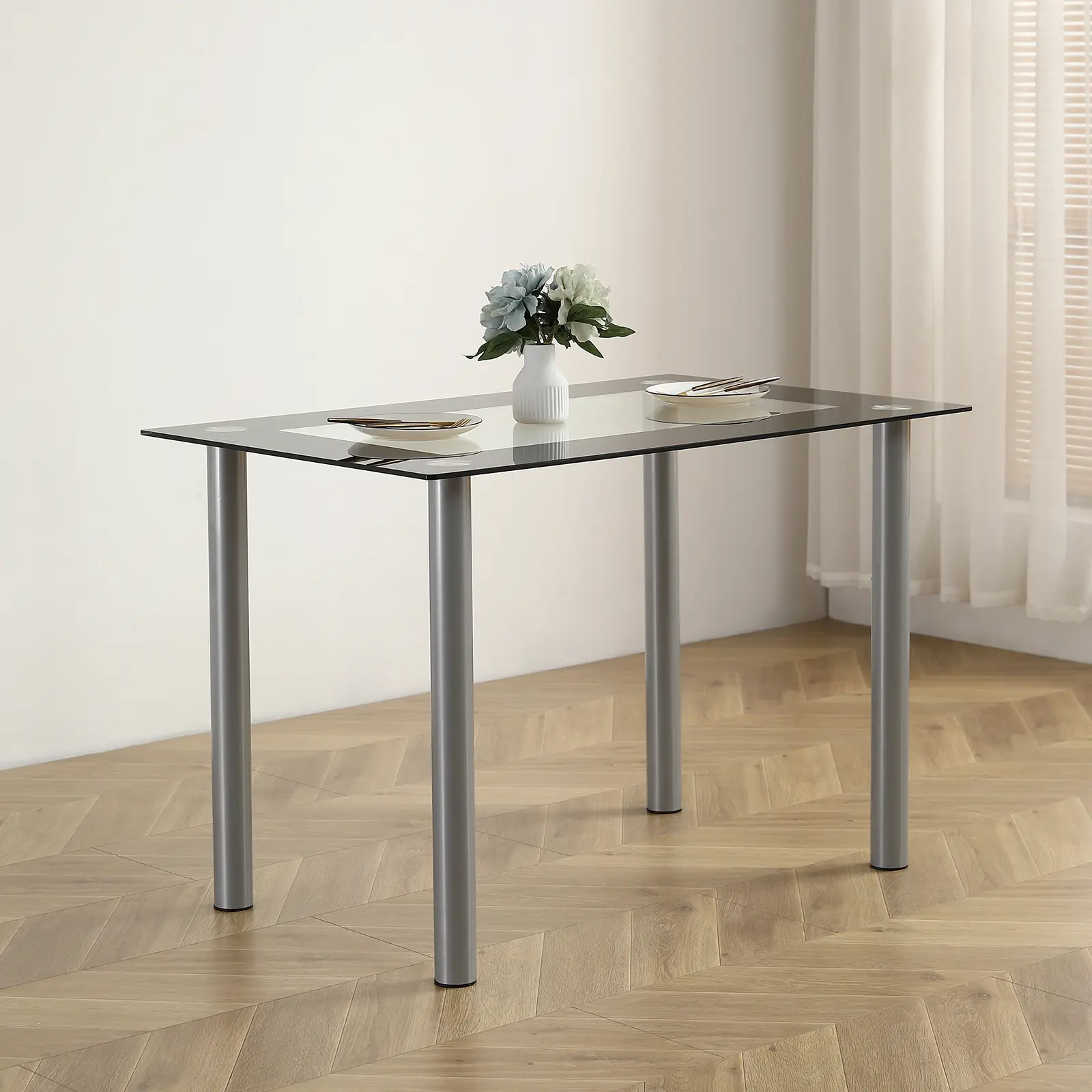 Minimalist design dining table - rectangular glass top, stainless steel cylindrical legs, suitable for 4 people, easy to clean, with black trim.