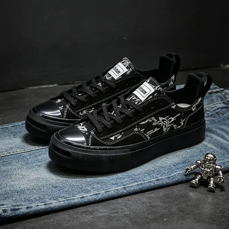 All-black graffiti star print thick-soled skate shoes; unisex matte black low-top canvas sneakers; gothic street style, hip-hop casual commuter athletic shoes; suitable for men, women, and teenage streetwear everyday wear.