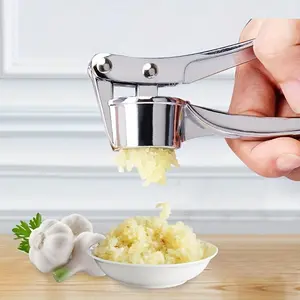 A Stainless Steel Garlic Press, a Circular Garlic Crusher Made of Stainless Steel, a Home Garlic Paste Maker, a Manual Mashing Tool for The Kitchen, And a Handheld Ginger Press Accessory for Home Use