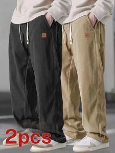 Two men's casual pants featuring a simple and versatile style with drawstring design, adding a casual feel. The pants have delicate small details, making them full of texture. The loose fit provides comfortable and relaxed wear, suitable for everyday outi