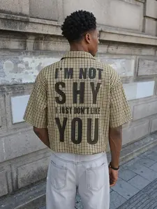Men’s Brown Plaid “I’m Not Shy I Just Don’t Like You” Print Cropped Cuban Collar Shirt, Streetwear Short Sleeve Button-Up with bold black text, retro gingham pattern, perfect for casual outings, edgy street style, and everyday wear for a sarcastic, statem
