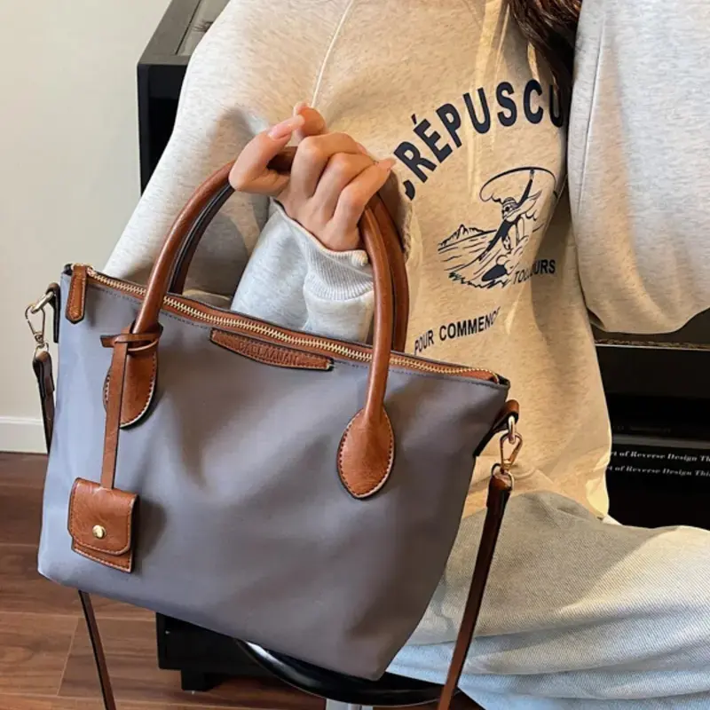 Nylon PU color-block handbag, multifunctional commuter crossbody bag, stylish casual shoulder bag for everyday use, waterproof lightweight nylon dumpling bag, women’s tote bag with adjustable shoulder strap.