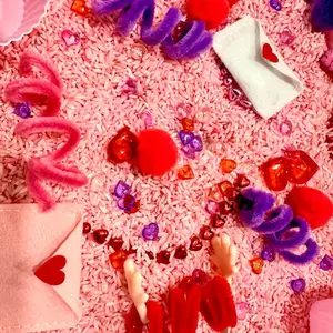 Valentine’s Day Themed Sensory Bin with Assorted Craft Supplies, Colorful Elements, and Heart-Shaped Features