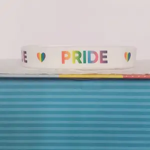 LGBTQIA+ PRIDE Silicone Wristband showing "PRIDE" with a Rainbow heart in between all around the band. Rainbow letters over a white band. Our original and discontinued line, adopt yours today before it's sold out. = )