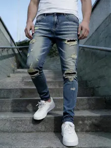 Men's blue distressed and ripped stretch jeans, with a slim-fit street silhouette for a narrative masterpiece, featuring unique patches to reconstruct vintage memories, allowing seamless switching between commuting and street scenes with one click