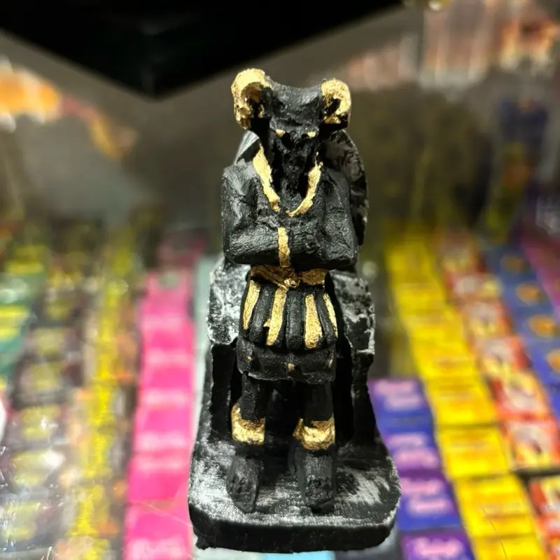 Small mamon statue sitting in a chair