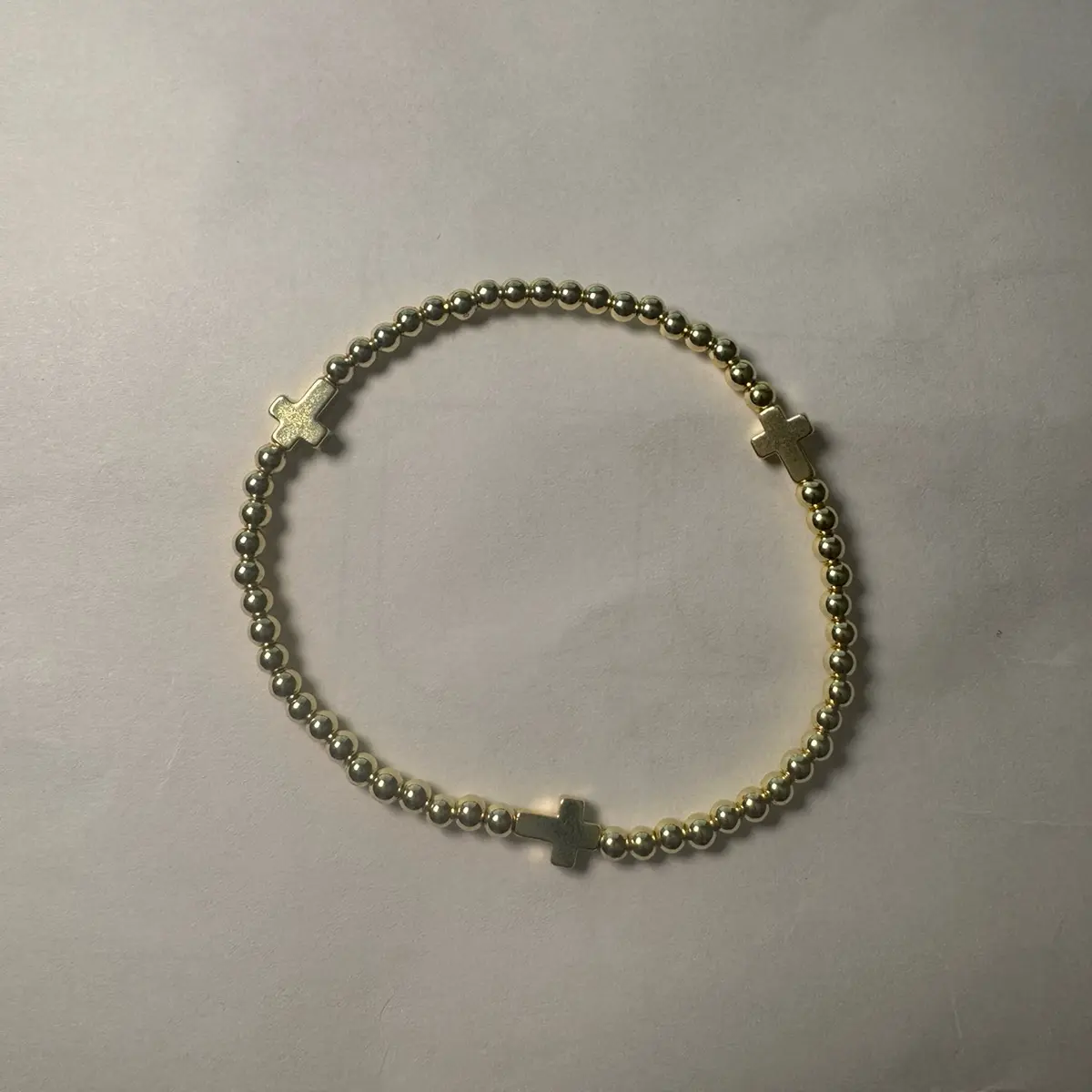 The Blessing Bracelet THREE CROSES This stretch bracelet is a beautiful accessory that can be worn comfortably on any wrist size. The bracelet features round gold hematite beads that add a touch of elegance to the design. The gold hematite crosses are the