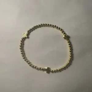 The Blessing Bracelet THREE CROSES This stretch bracelet is a beautiful accessory that can be worn comfortably on any wrist size. The bracelet features round gold hematite beads that add a touch of elegance to the design. The gold hematite crosses are the