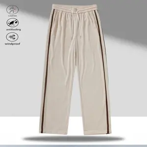A pair of apricot-colored corduroy straight-leg casual pants with brown side stripes, featuring a retro casual style. The drawstring waistband allows for flexible adjustment to fit different waist sizes, making them easy to wear and comfortable. The class
