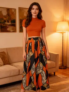 A women's set, Casual fashion set, featuring an orange fitted short turtleneck top paired with a color-blocked leopard geometric print wide-leg long skirt. The style is retro and unique, suitable for dinner parties, dates