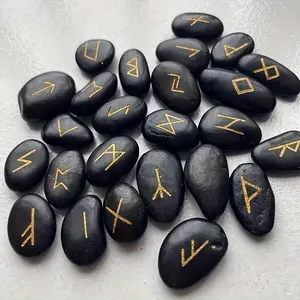 A set of 25 natural black river stones engraved with gold runes, ideal for Wicca, mysticism, chakra work, and witchcraft supplies, includes a bag.