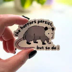 The Horrors Persist, But So Do I Opossum Sticker