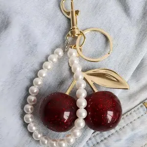 Cute cherry design keychain Stylish metal keychain Can be used as a keychain, bag charm, birthday gift, holiday gift Includes hook and pearl string Delicate sparkling bag charm Available in pink, black, red, three colors