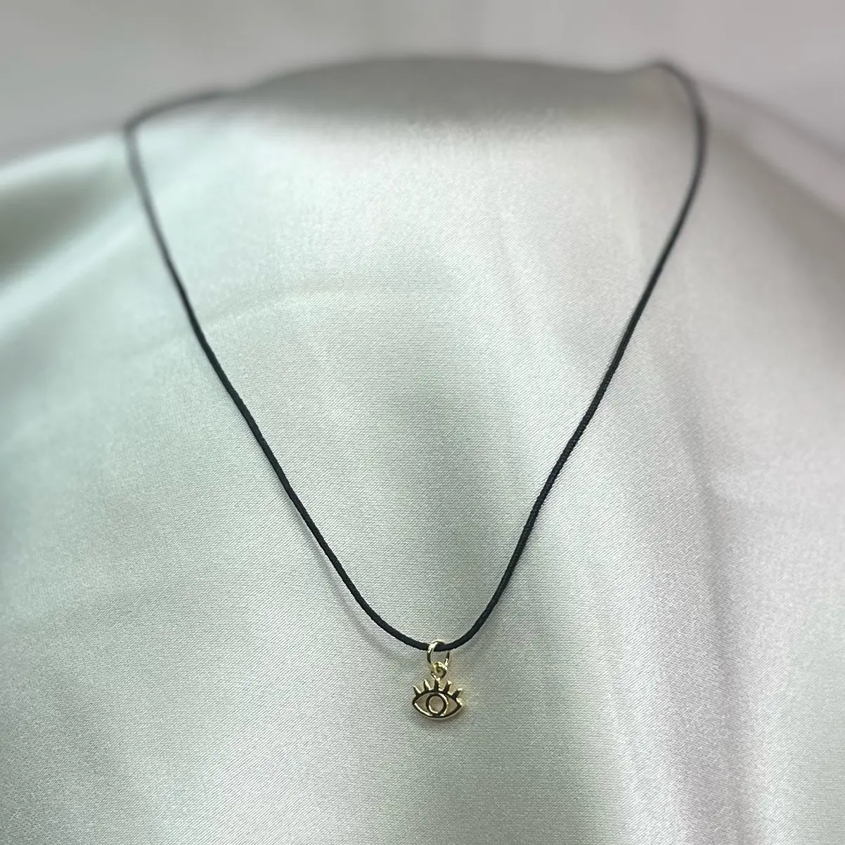 Collar de hilo negro con dije de ojo en rodio para protección