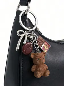 A brown teddy bear keychain pendant, cute bear coffee bean chocolate design pendant, fashionable handbag accessory keychain, aesthetic decoration suitable for tote bags, shoulder bags, and backpacks.