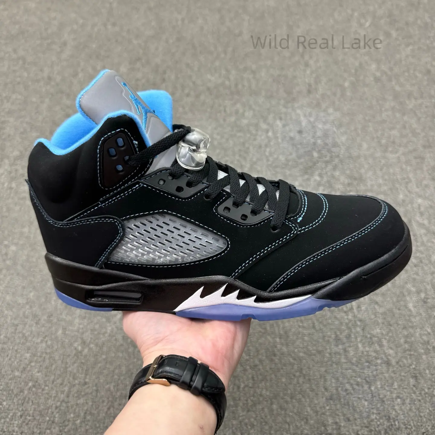 Vintage old school solid black fluffy suede basketball trainers, light blue plush inner collar, perforated mesh panel detail, wear resistant see-through ice blue rubber outsole, rugged monochrome street sneakers for hip hop & skate culture outfits