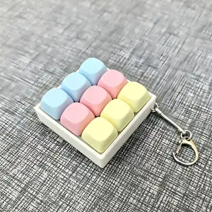 9-key mechanical keyboard key chain — blue, pink, and yellow textured base — customizable cap colors