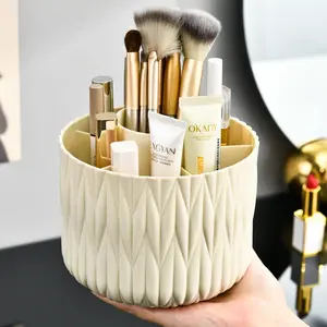 360-degree rotating makeup storage box with 7 compartments made of plastic, featuring luxurious striped design, removable makeup brush rack, suitable for use on desks, dressing tables, and offices.