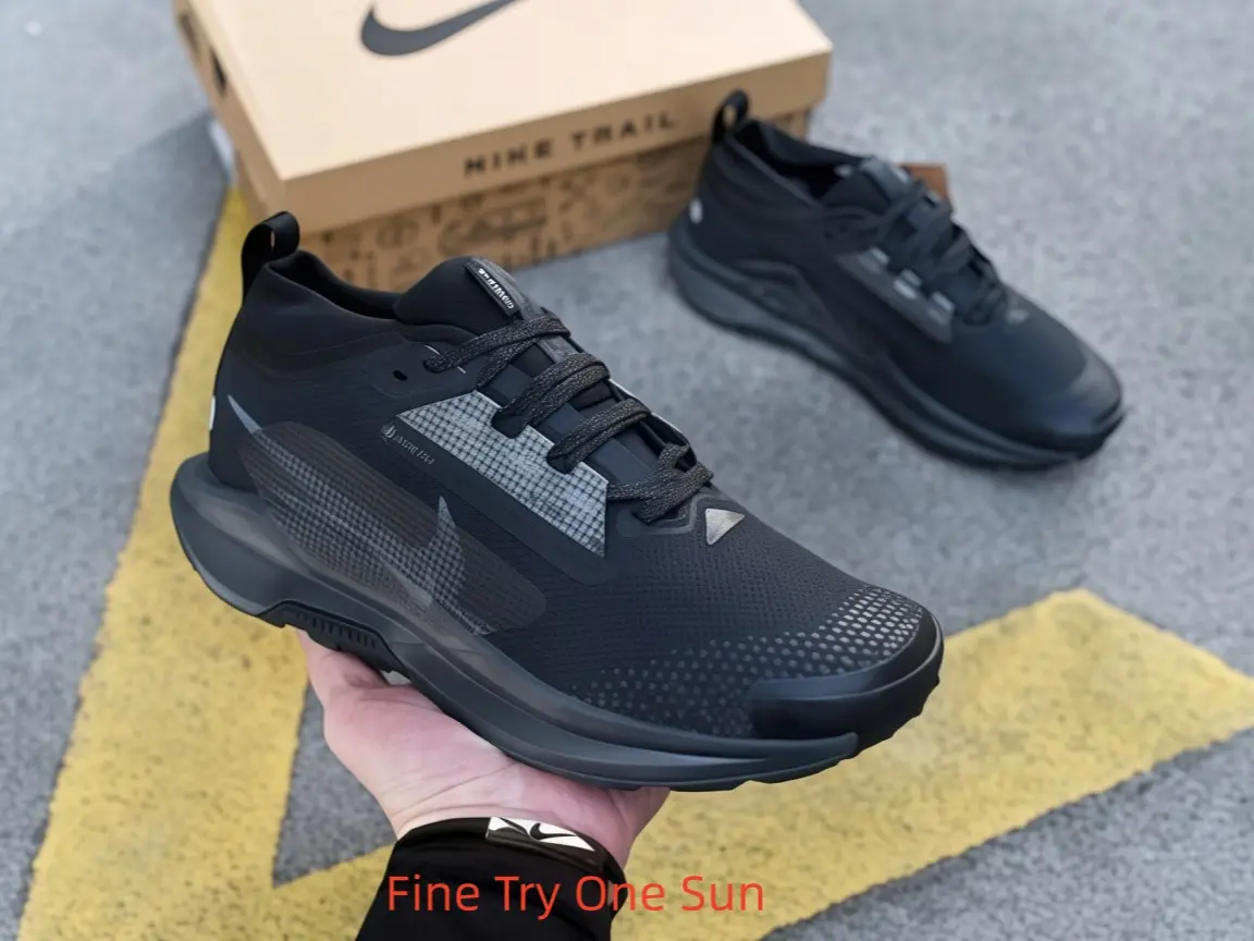 Full matte black low-top collectible sneakers, rugged trail mesh with translucent reflective grey side overlays