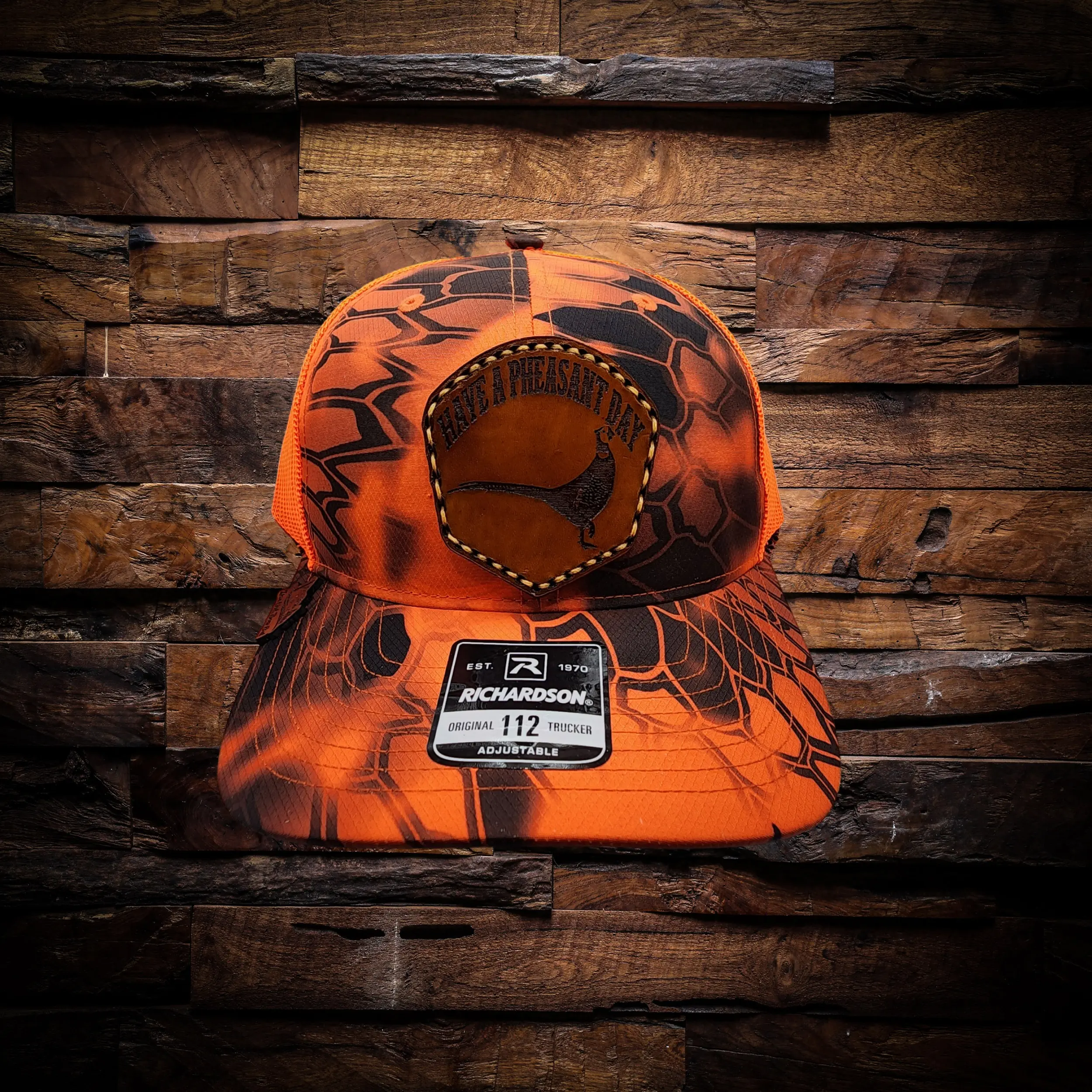'Have a Pheasant Day' Leather Patch on a Blaze Orange Richardson 112p Trucker Hat with Kryptek Camo