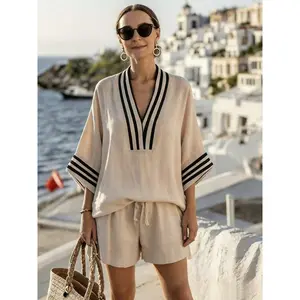 A Relaxed Two-Piece Summer Outfit For Women In A French Style – Featuring A Greek-Inspired V-Neck Top With Wide Sleeves And High-Waisted Shorts, Perfect For Casual Elegance And Comfort At The Beach