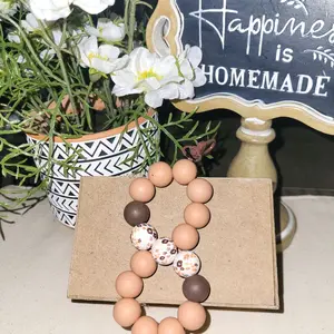 Earth Tone Infinity Keychain or Accessory with Natural Beads and Patterned Beads on Kraft Box Background