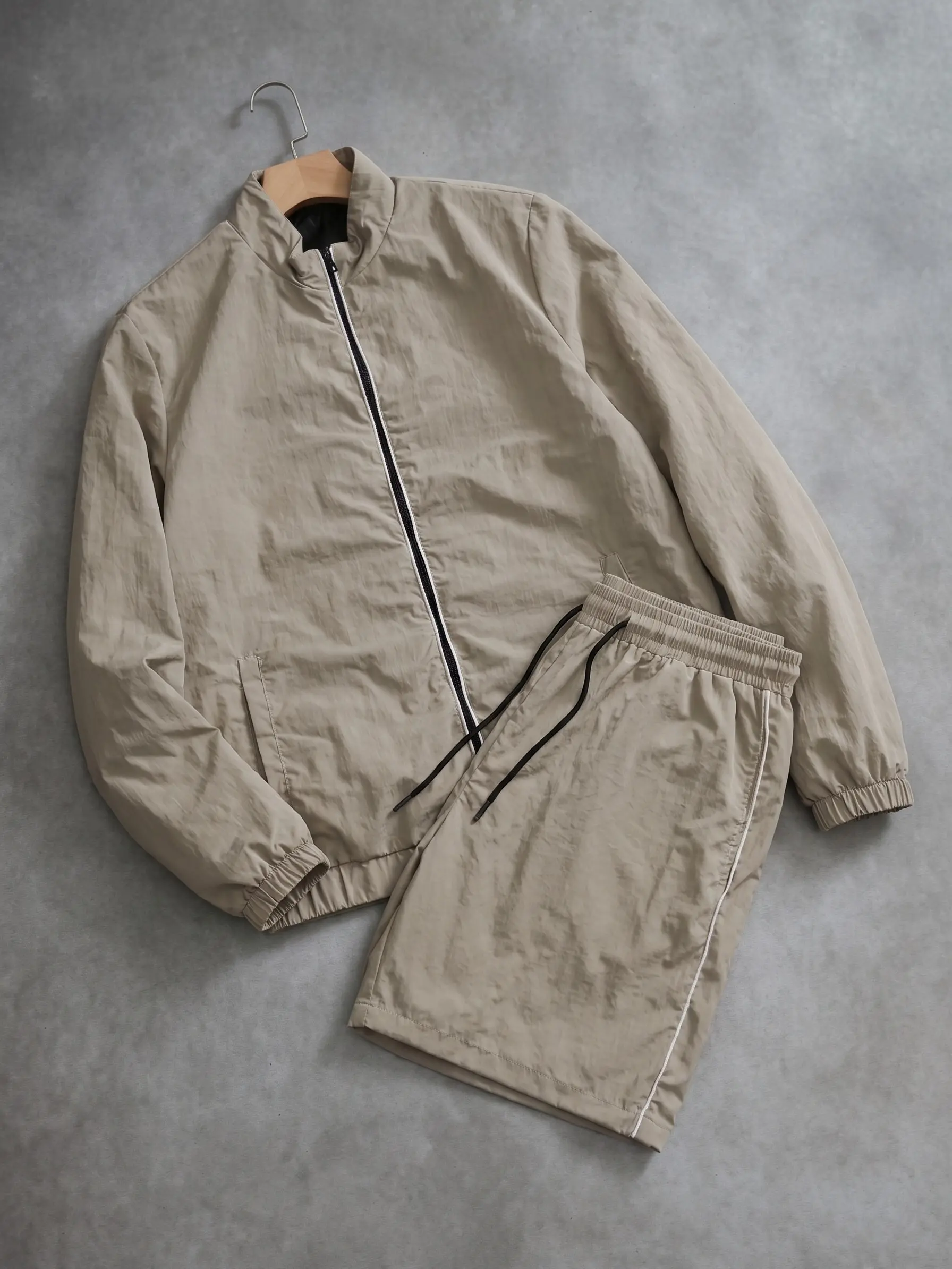 Minimalist solid-color casual athletic set: stand-collar cardigan jacket paired with drawstring shorts. Men’s lightweight two-piece outfit for everyday wear, versatile.