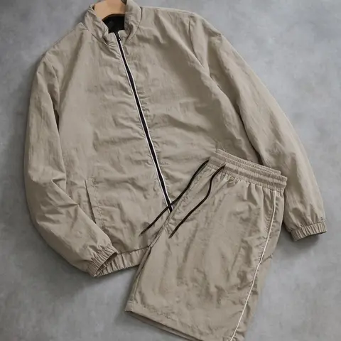 Minimalist solid-color casual athletic set: stand-collar cardigan jacket paired with drawstring shorts. Men’s lightweight two-piece outfit for everyday wear, versatile.