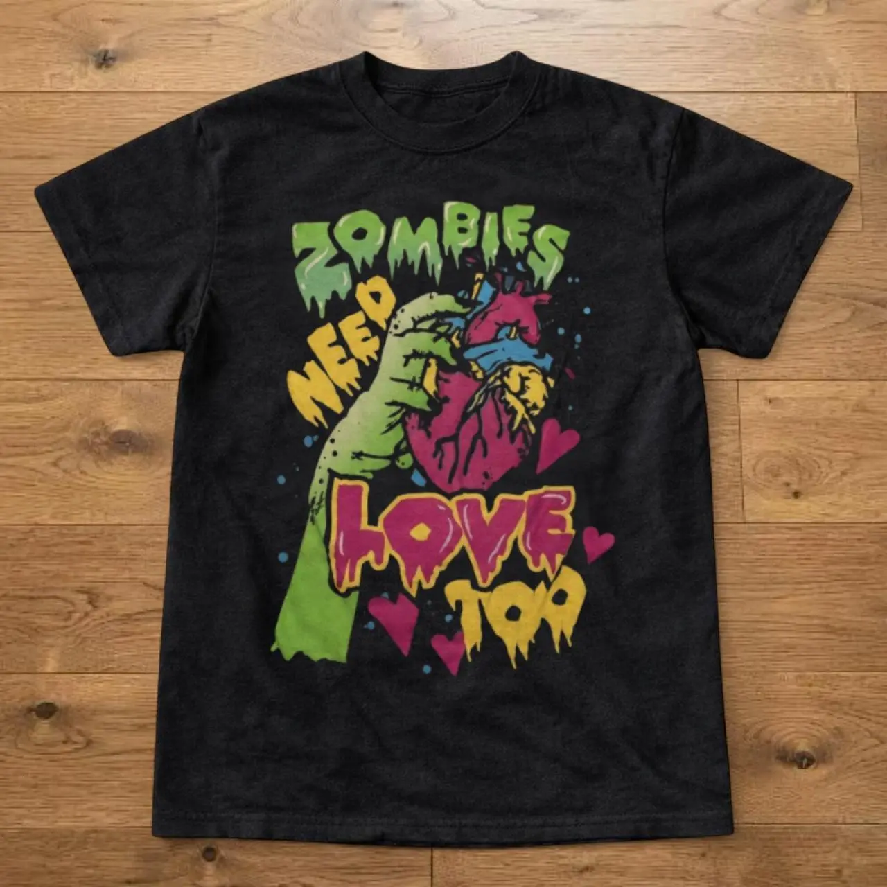 Zombies Need Love Too Zombie Hand Holding Heart Graphic T shirt and Baby Tee | Vintage Horror Movie Cartoon Streetwear | Alt Gothic Graphic Tee