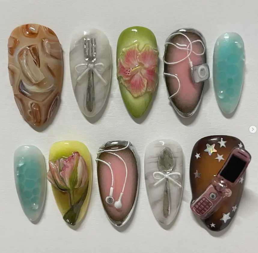 Whimsical Y2K nails with 3D forks, spoons, hibiscus, tulip, iPod with earbuds, flip phone, and dreamy gradient bases – retro nostalgic manicure