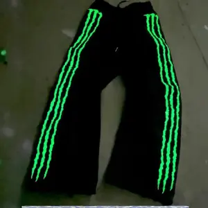 Streetwear jogger pants with claw-shaped fluorescent three-stripe embroidery, a glow-in-the-dark effect, made of cotton with a drawstring; hip-hop style, casual design.