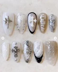 Gothic silver and white nails with crosses, lace, metallic stars, and edgy lettering—perfect for a dark yet elegant, cathedral-inspired aesthetic