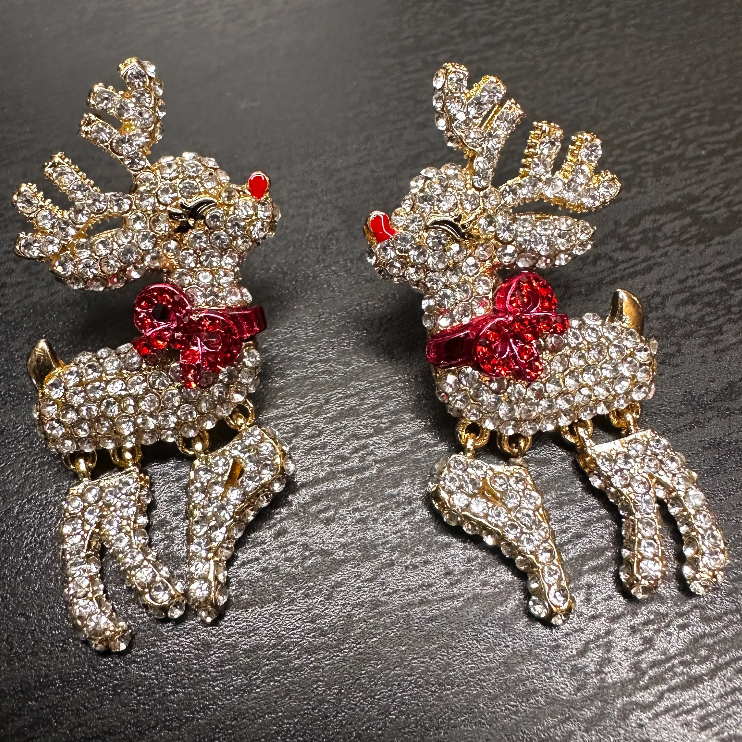 Crystal Reindeer Drop Earrings, the perfect festive accessory for Christmas celebrations, holiday parties. Dazzling rhinestones, vibrant red accents, and playful dangling leg details, these earrings add a touch of whimsy and elegance to any outfit.