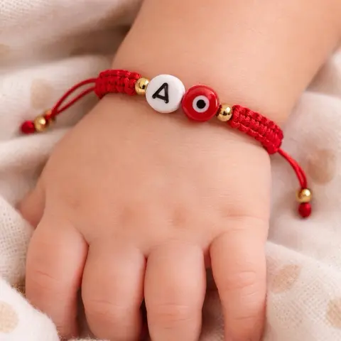 Adjustable red bracelet with evil eye and initials.