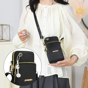 Fashionable lady's crossbody phone bag with adjustable shoulder strap. Suitable for holding phone, cards and wallet. Durable nylon material, with a golden floral emblem. Ideal choice for daily commuting and casual outings. Phone bag.